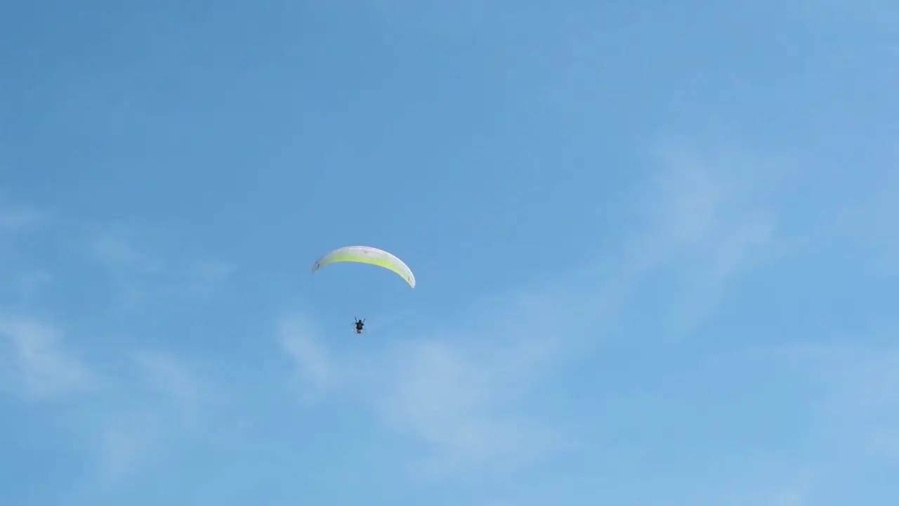 Paraglider approaching over a blue sky