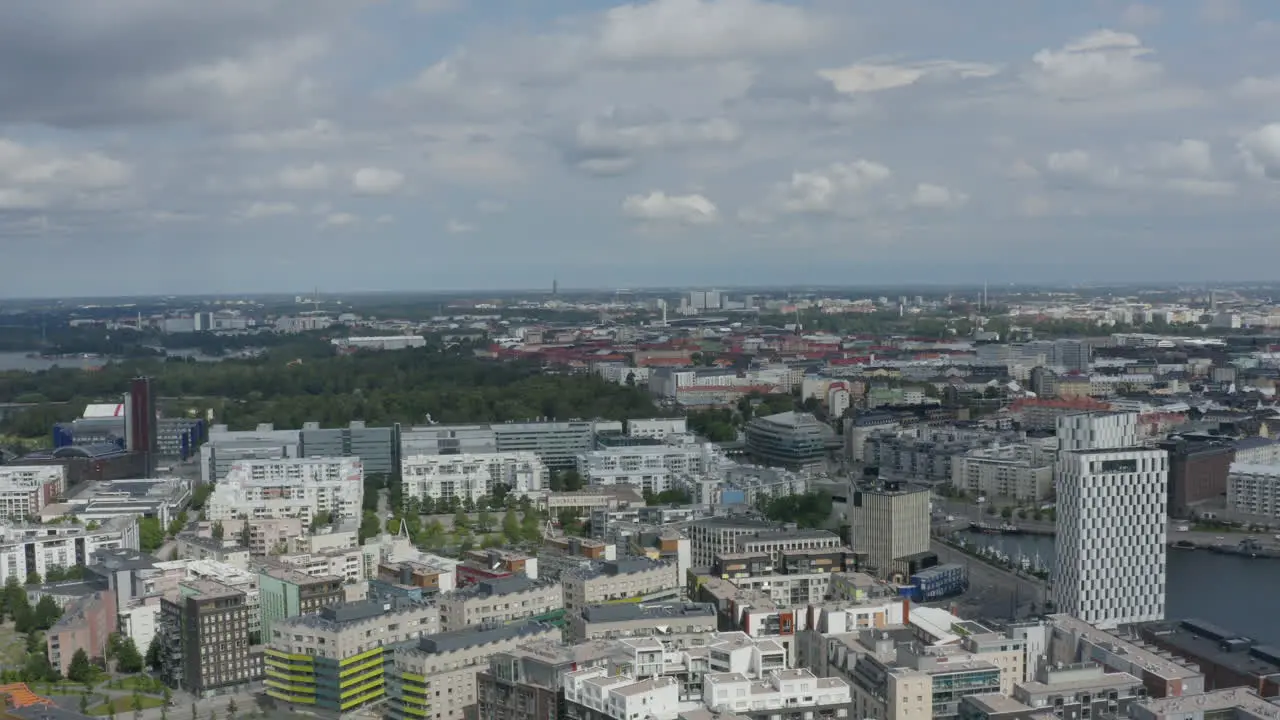 Sprawling city of Helsinki on river with green park long drone shot