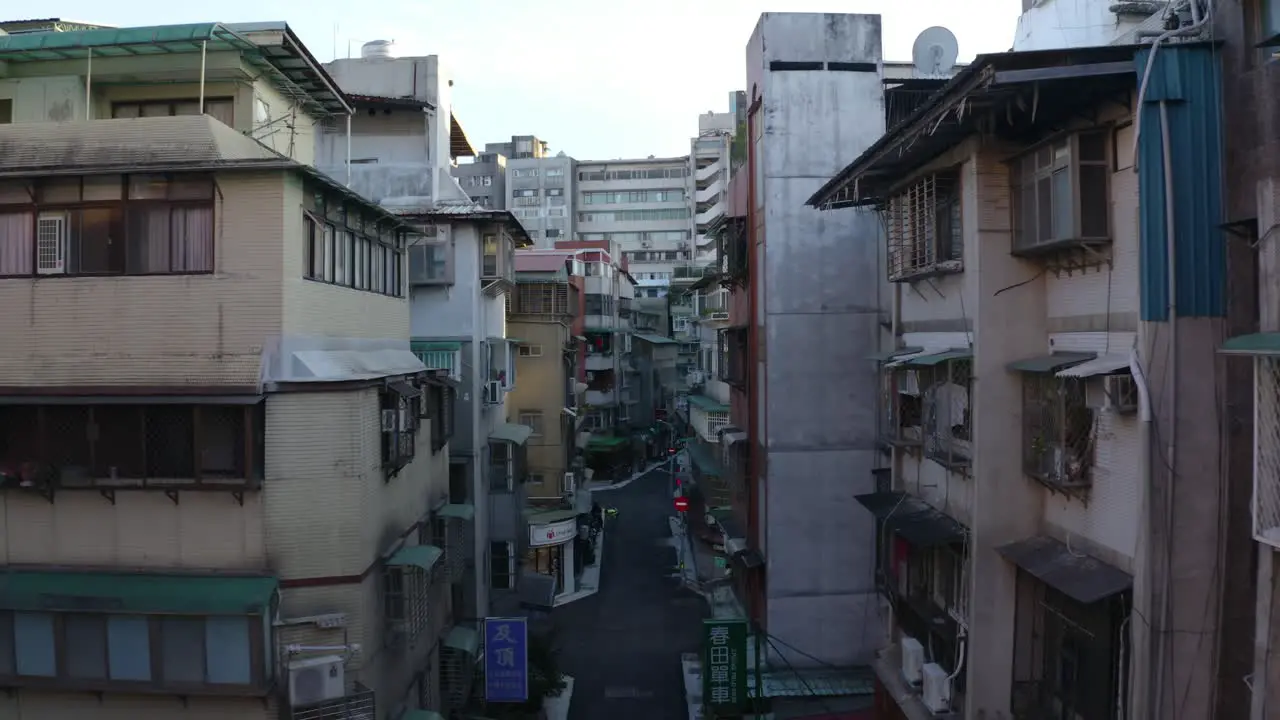 Drone shot of a street in Taipei city center moving between narrow building