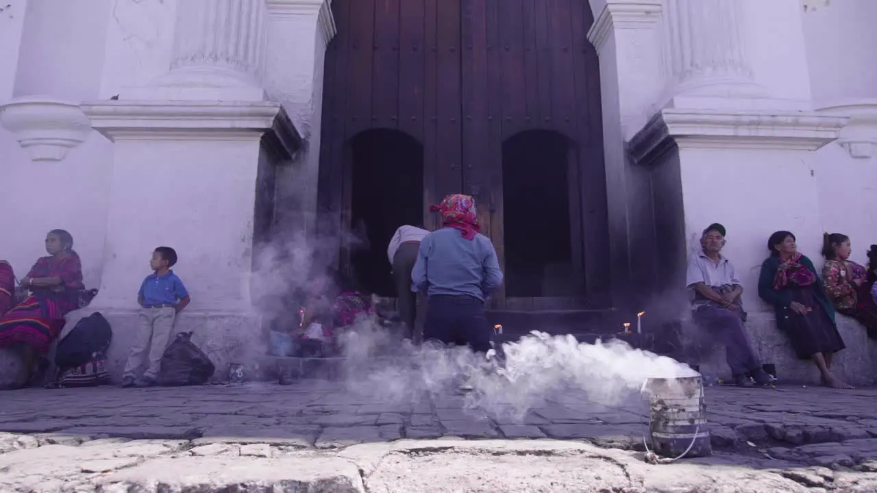 Entrance of an old catholic church in Chichicastenango Guatemala while a man performs a religius ceremony