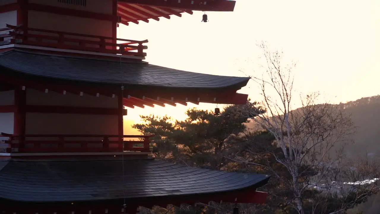 Beautiful silhouette of Pagoda with sun setting in background behind hills