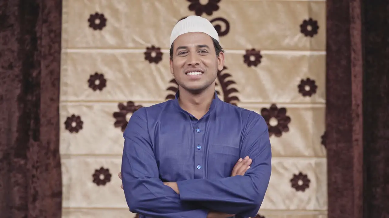 Confident Muslim man standing crossed hands smiling