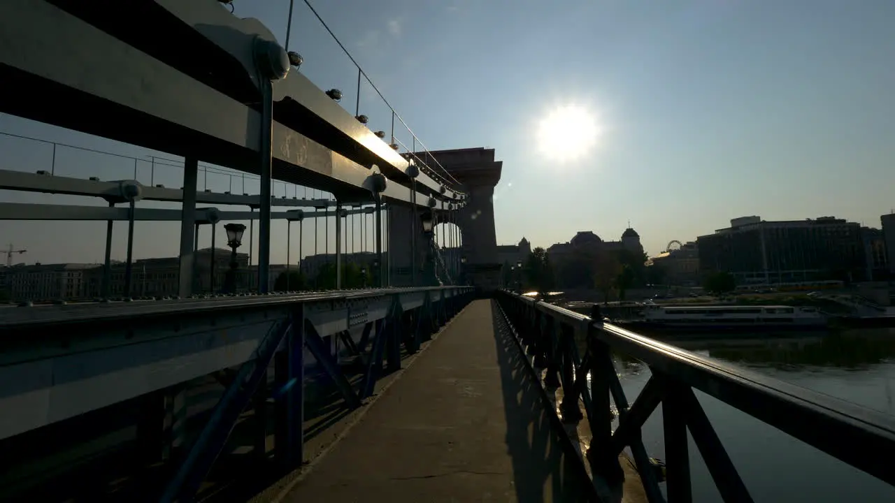 Walking through Chain bridge at sunrise Budapest Hungary