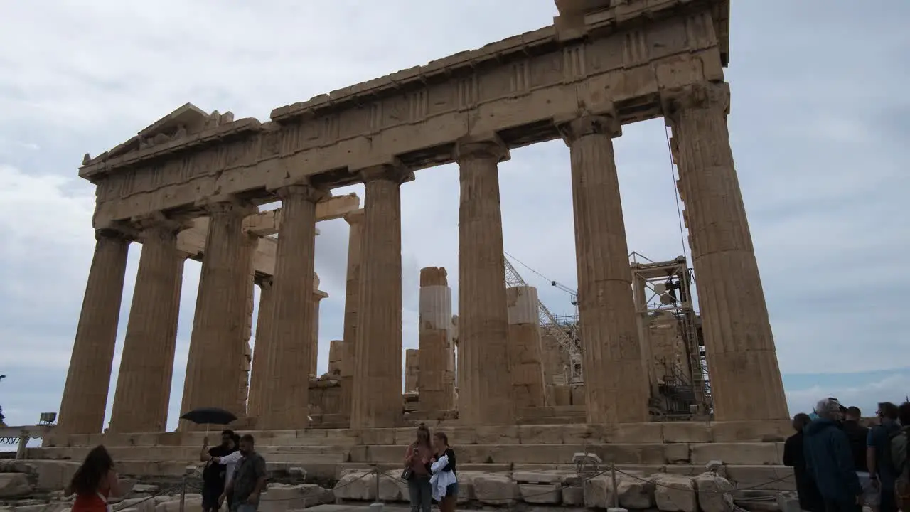 Pan shot Parthenon temple with tourist around on the Acropolis in Athens Greece on 10-15-2021