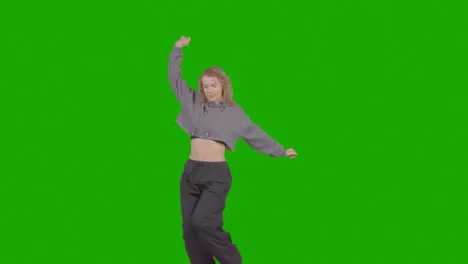 Studio Shot Of Young Woman Having Fun Dancing Against Green Screen 35