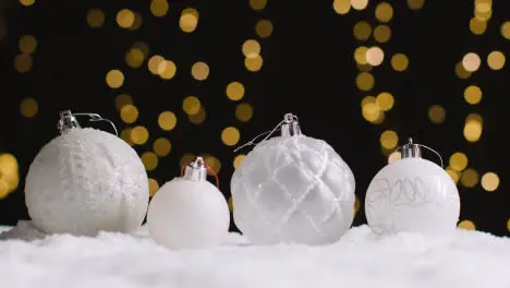 Studio Christmas Still Life With Decorations On Snow And Lights In Background