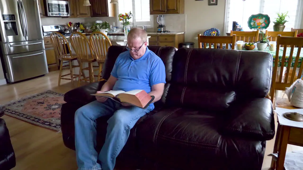 A lonely older man seeking help reads the Holy Bible