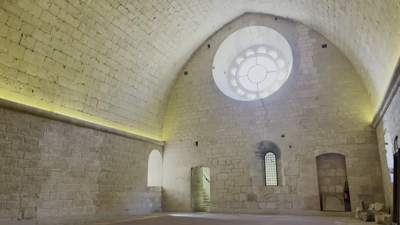 Large dormitory in a monastery with high sandstone side walls a large round window empty