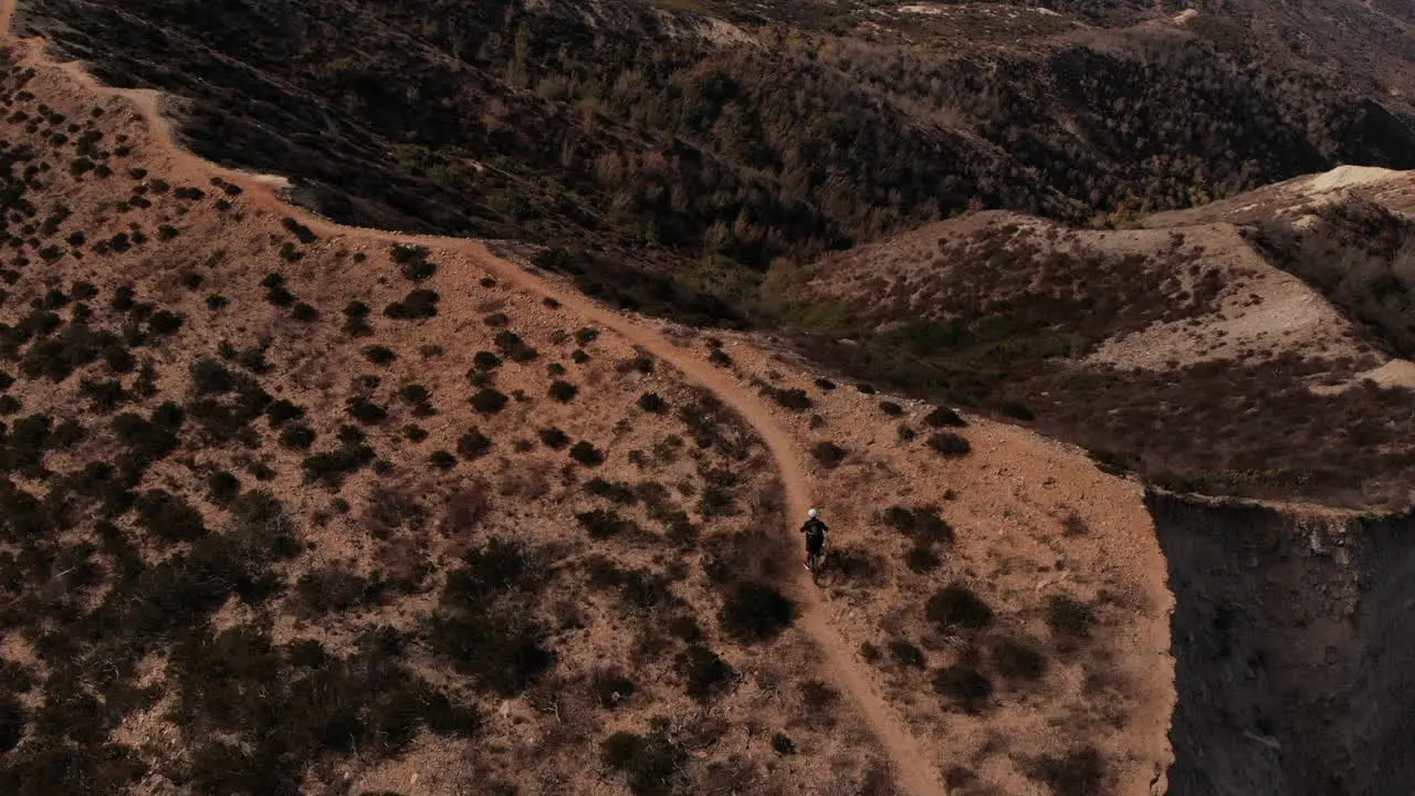 A man riding the mountain in bike with black outfit