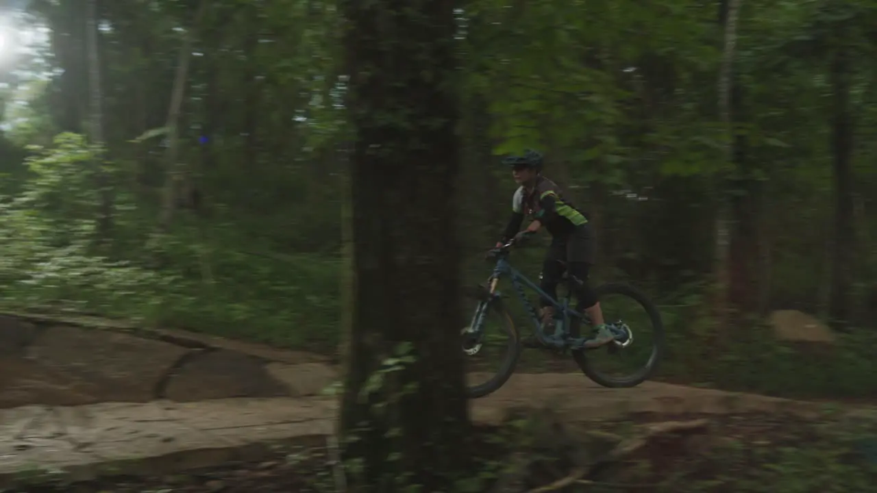 person wearing a helmet riding on a bicycle on a bicycle trail in the forest