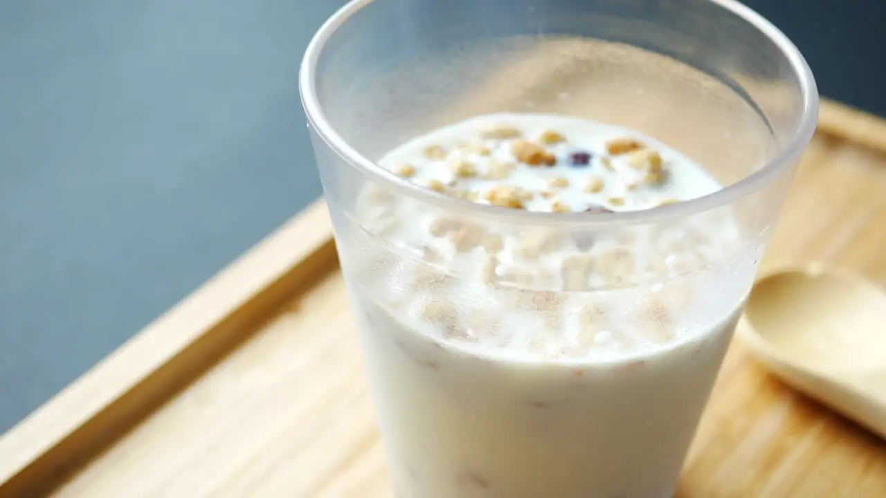 Breakfast cereal and milk in a glass on table 