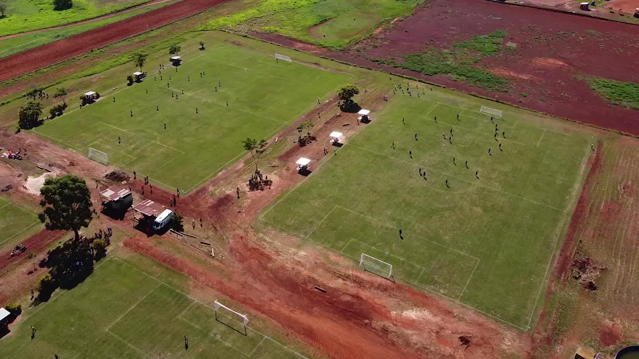 Drone orbit around multiple football fields with teams playing football Posadas hipodrome