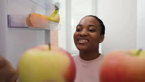 Woman taking salad bowl from the fridge