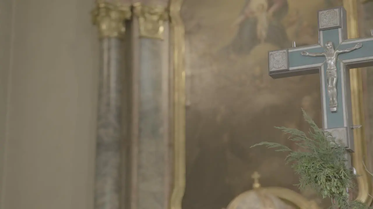 Close-up of a cross in the sanctuary of a church with a baroque altar in the background