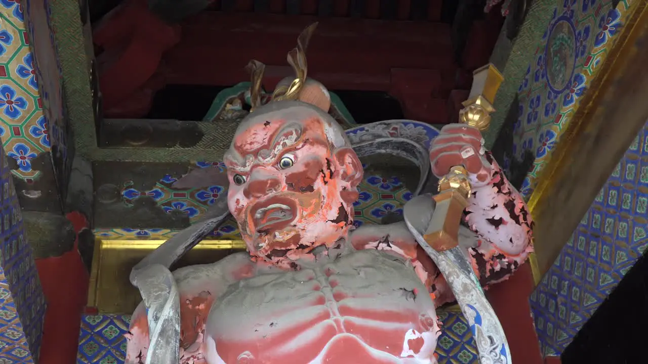 Statue of an old wooden god with evil look in the Toshogu Shrine temple in Nikko Japan