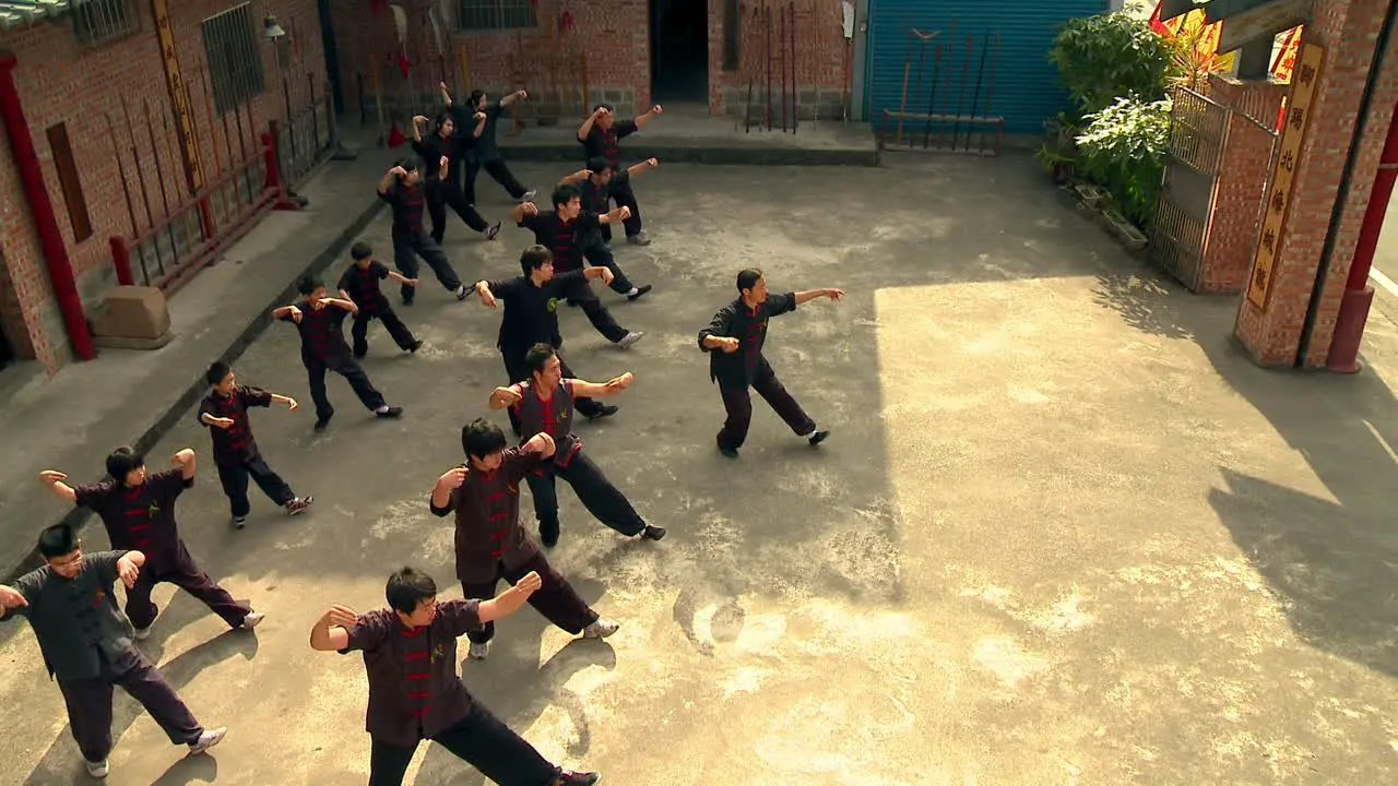 Group of young Chinese boys exercise powerful martial arts with teacher