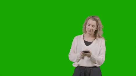 Studio Shot Of Young Woman Listening To Music On Mobile Phone And Dancing Against Green Screen 5