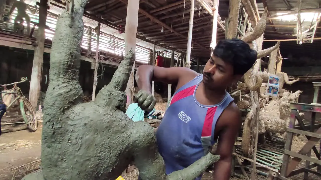 Poor Indian craftsman makes clay idols of Indian Gods and Goddess inside workshop