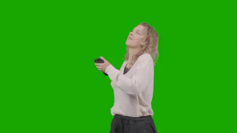 Studio Shot Of Young Woman Listening To Music On Mobile Phone And Dancing Against Green Screen 6