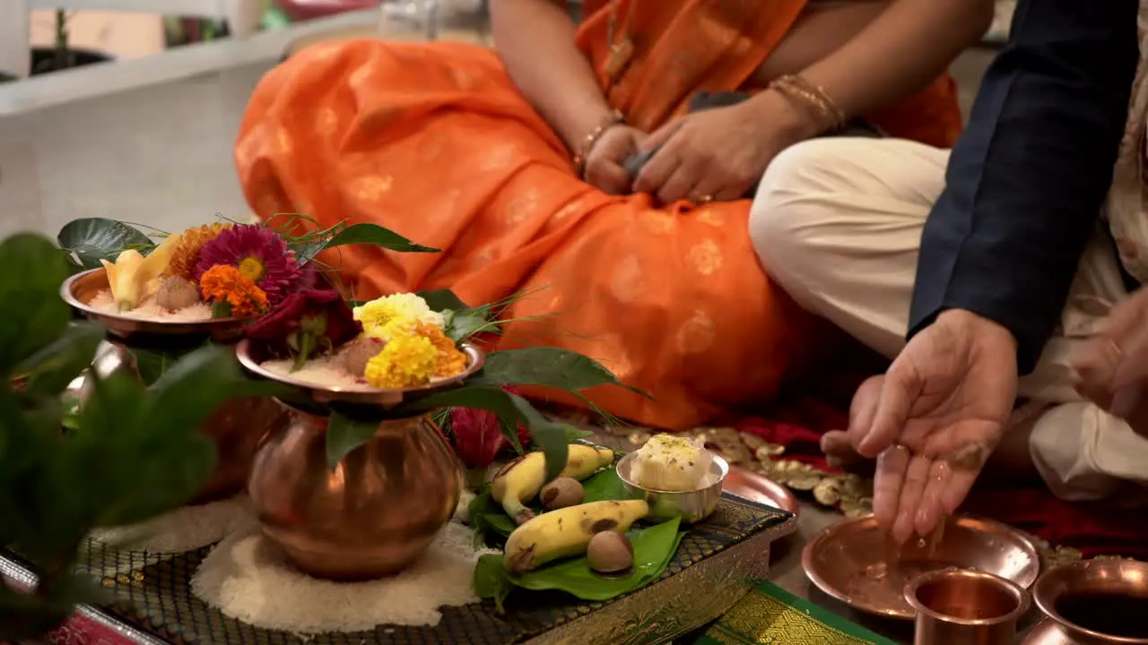 husband and wife both are seeting gruhpravesh pooja and droped water on hand