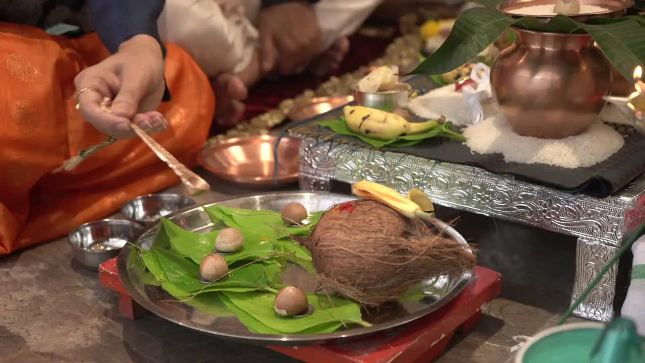 husband and wife both are seeting gruhpravesh pooja and droped water on supari