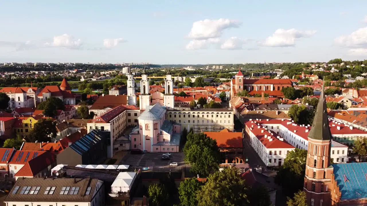 Kaunas city old town aerial drone shot while the drone is ascending and revealing a beautiful panorama of Kaunas old town and Kaunas suburbs in the distance