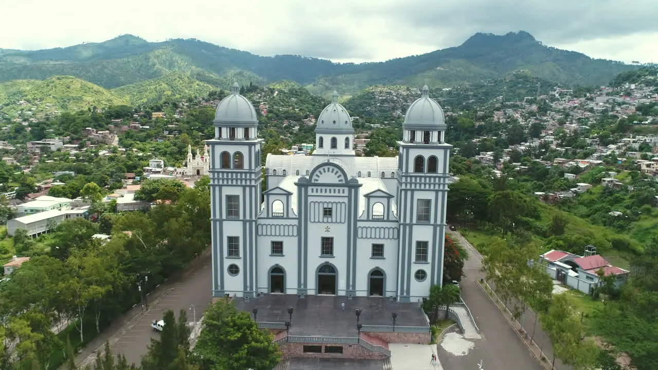 AERIAL Aerial zoom in of cathedral overlooking city and mountains