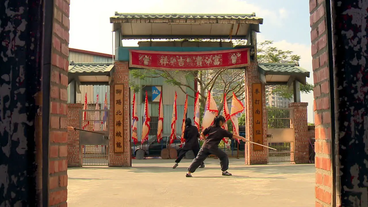 Young Chinese girls perform sword dance at martial arts school courtyard