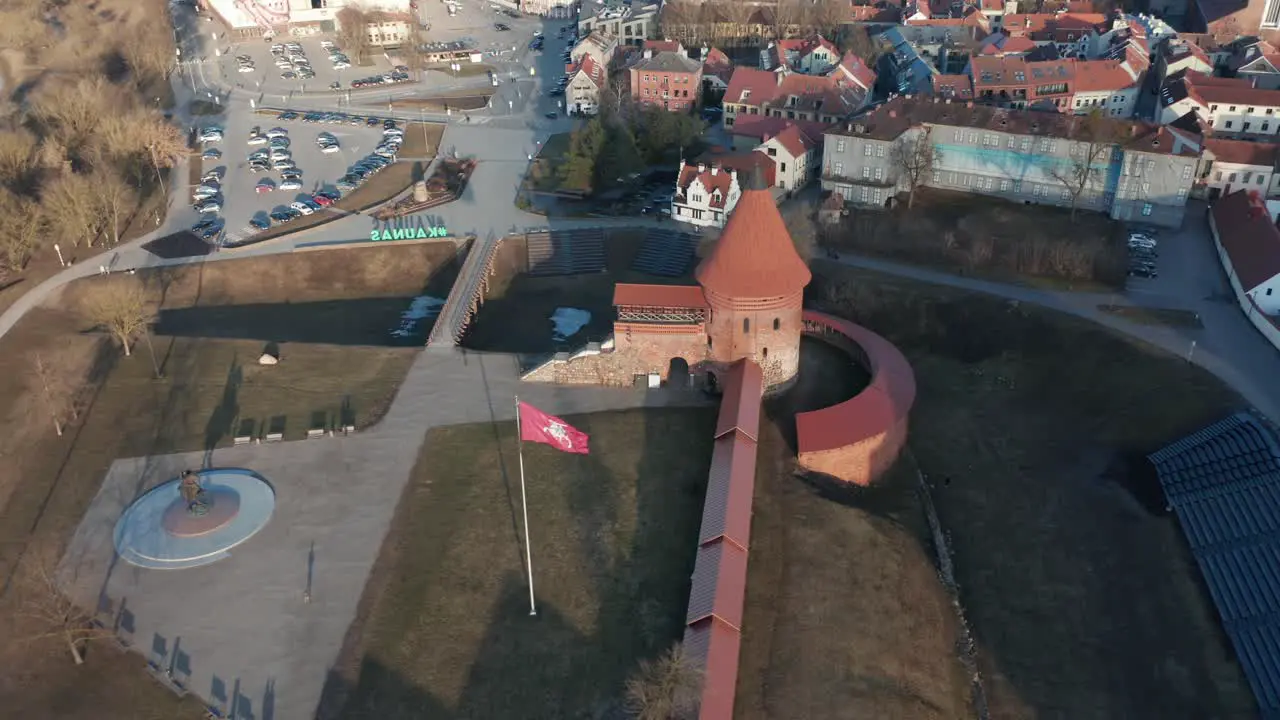 AERIAL Waving Lithuanian Flag near Kaunas Castle at a Golden Hour Evening