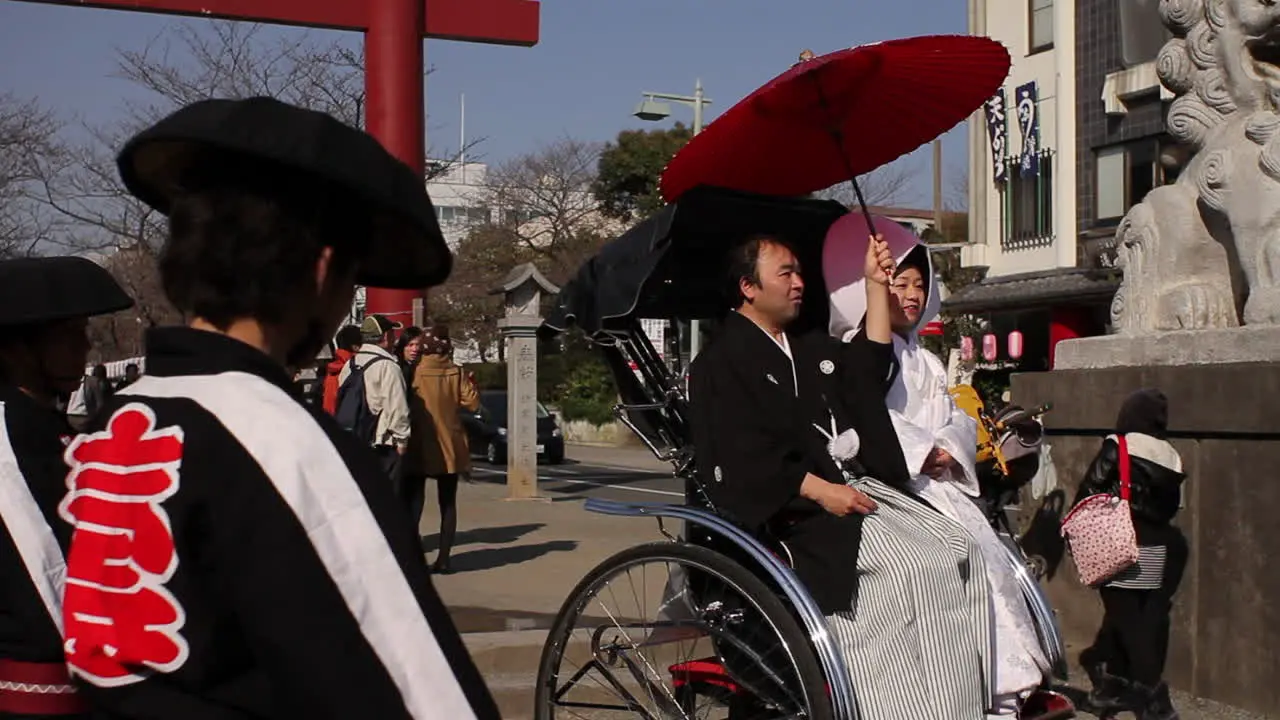 Wedding Couple on sitting on pulled rickshaw in Kamakura Japan