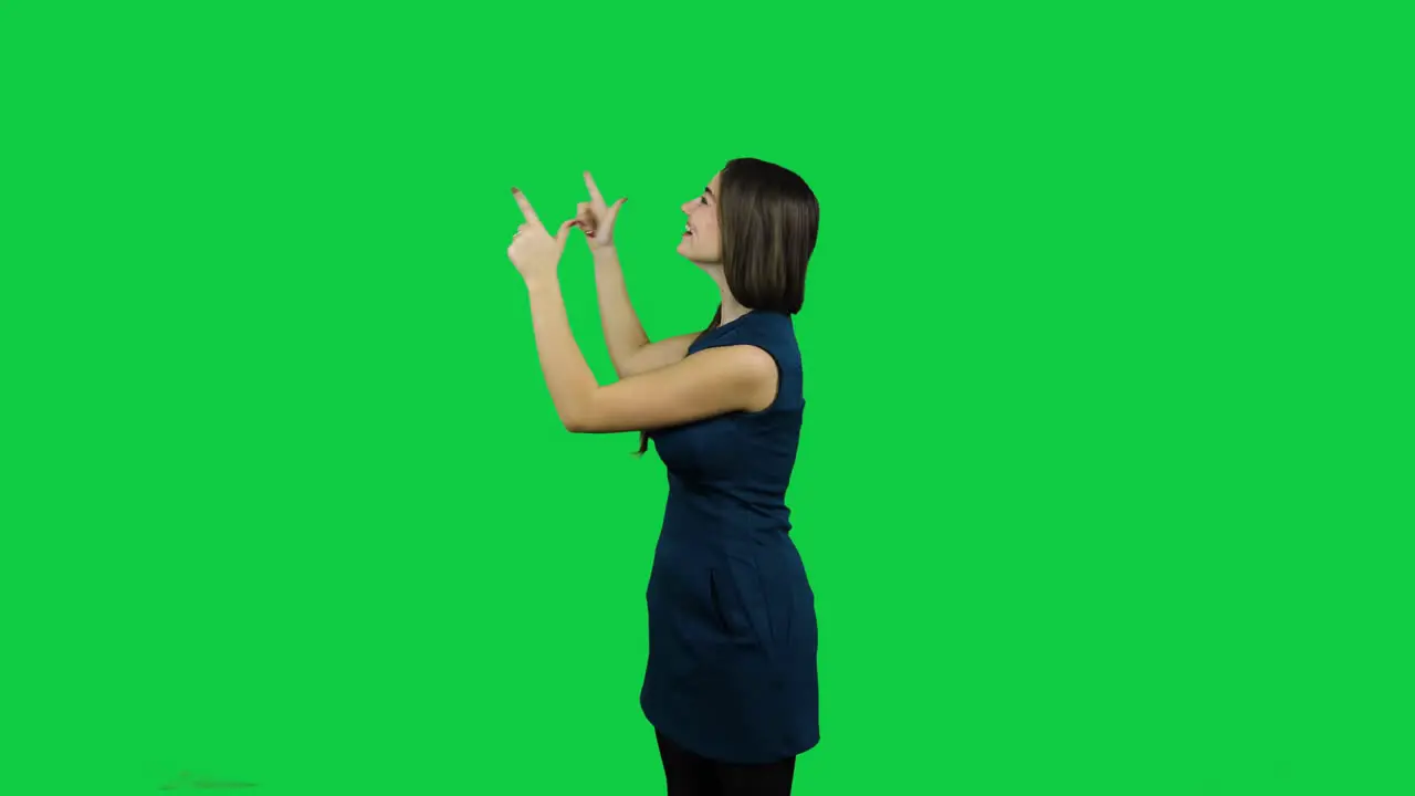 Happy excited girl pointing promoting in front of the green screen