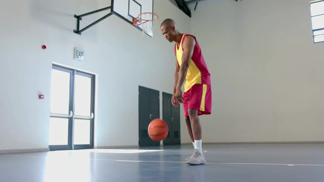 African American man practices basketball in a gym