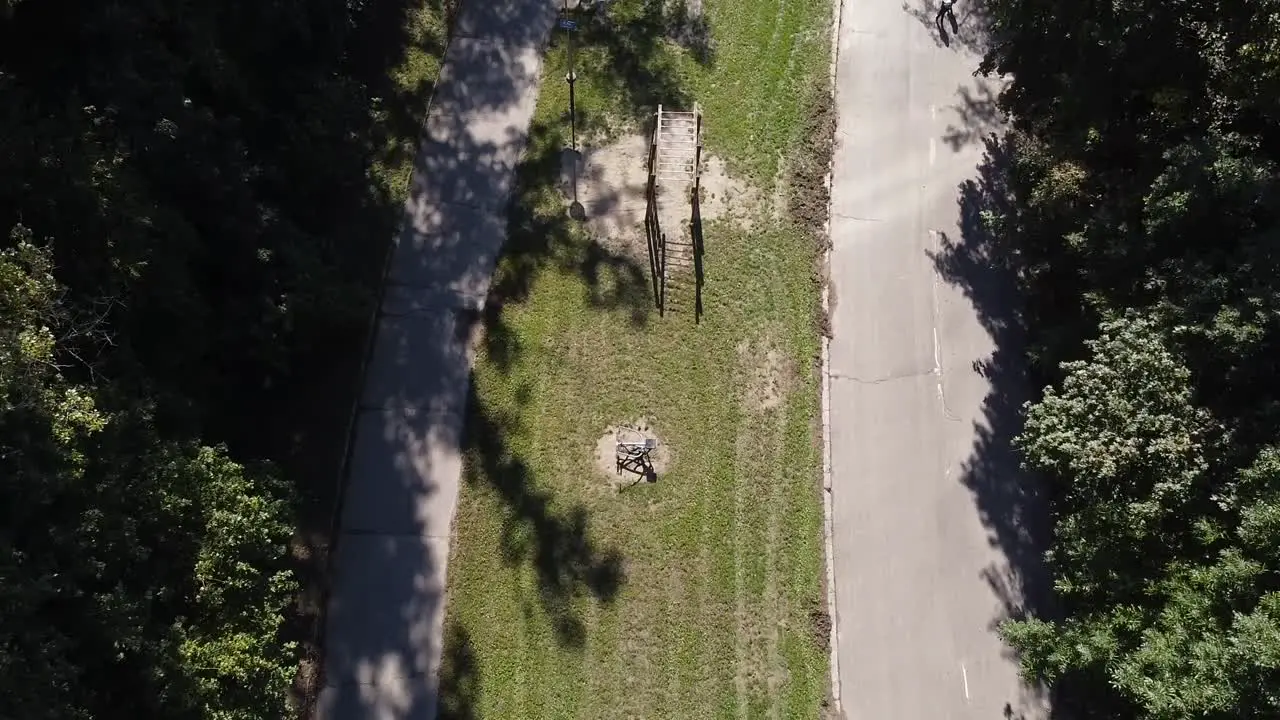 two kids running to parents with stroller in european green public park with excercise tools