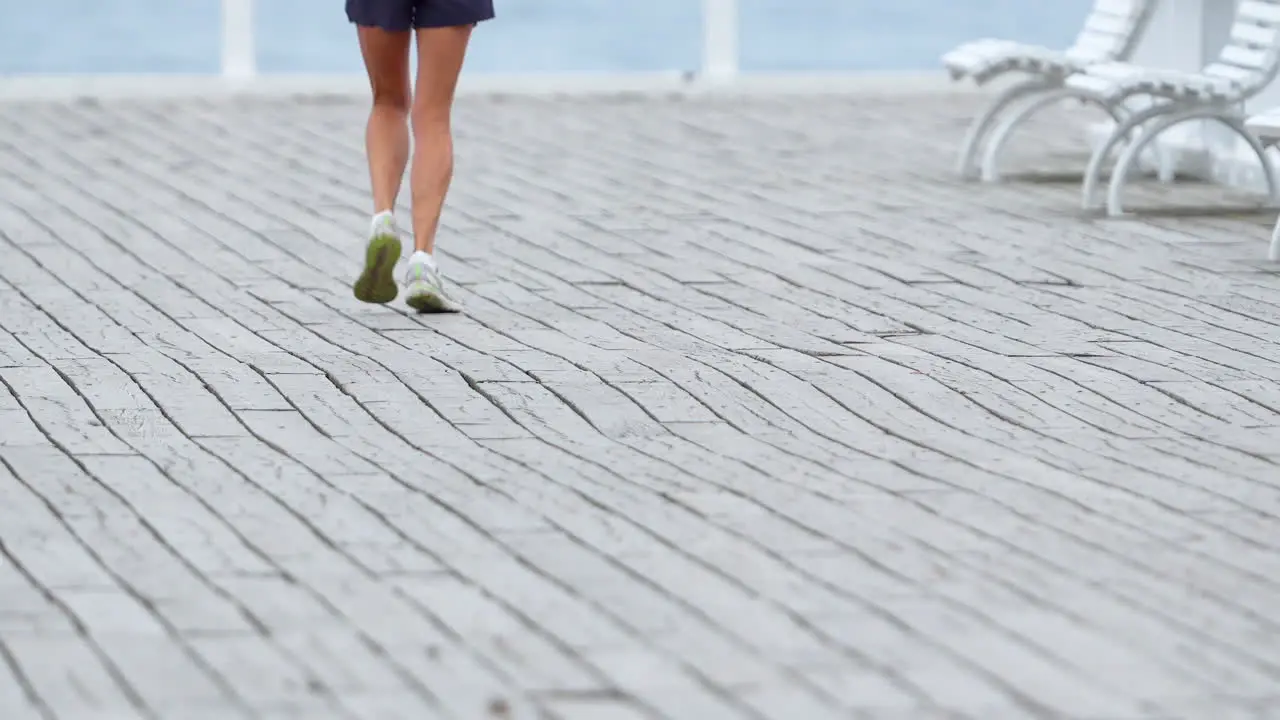 Slow Motion Capture of Woman Jogging on Brick-Paved Road Lower Half Legs