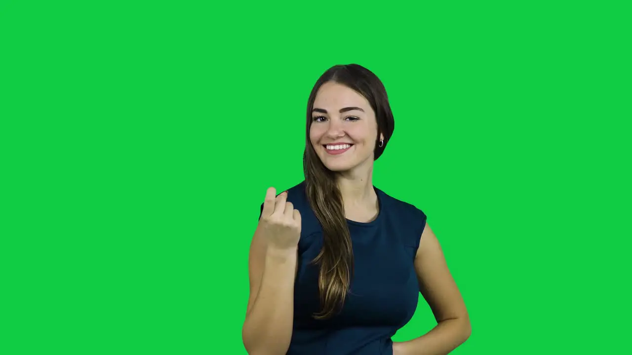 Girl call camera with one finger in front of a green screen