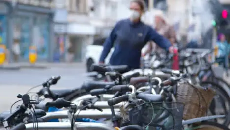 Defocused Panning Shot Revealing Bicycle Rack and City Crowd