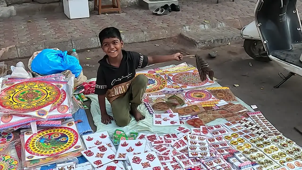 Wide shot a young boy is selling decorative items on the street road to make a living