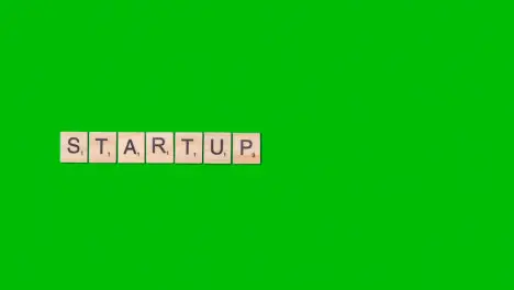 Stop Motion Business Concept Overhead Wooden Letter Tiles Forming Word Startup On Green Screen 1