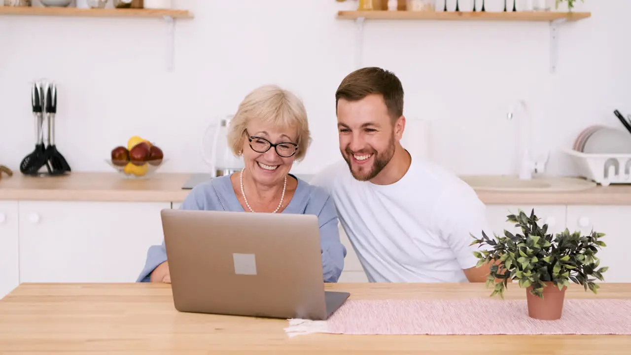 Glückliche ältere Mutter Und Erwachsener Sohn Sitzen Am Tisch Im Kitcken Und Sprechen über Videoanruf Auf Modernem Laptop