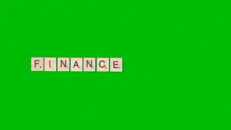 Stop Motion Business Concept Overhead Wooden Letter Tiles Forming Word Finance On Green Screen 1