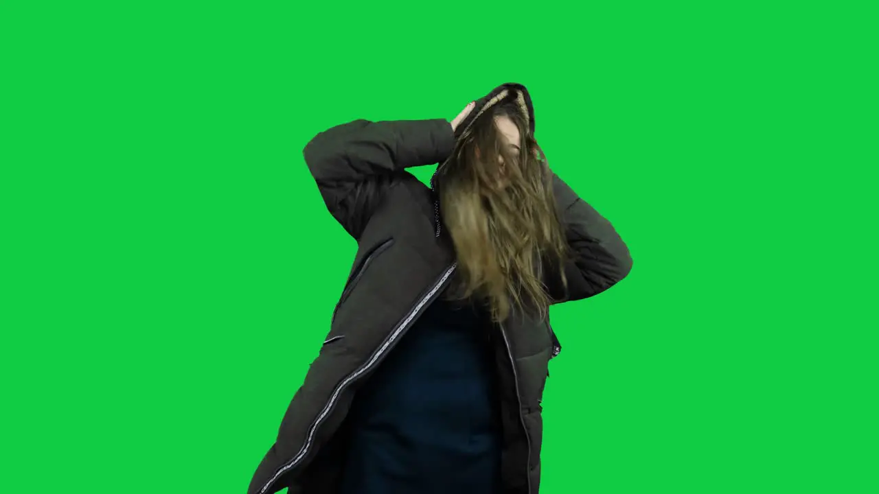 Happy girl playing around with the jacket in front of the green screen