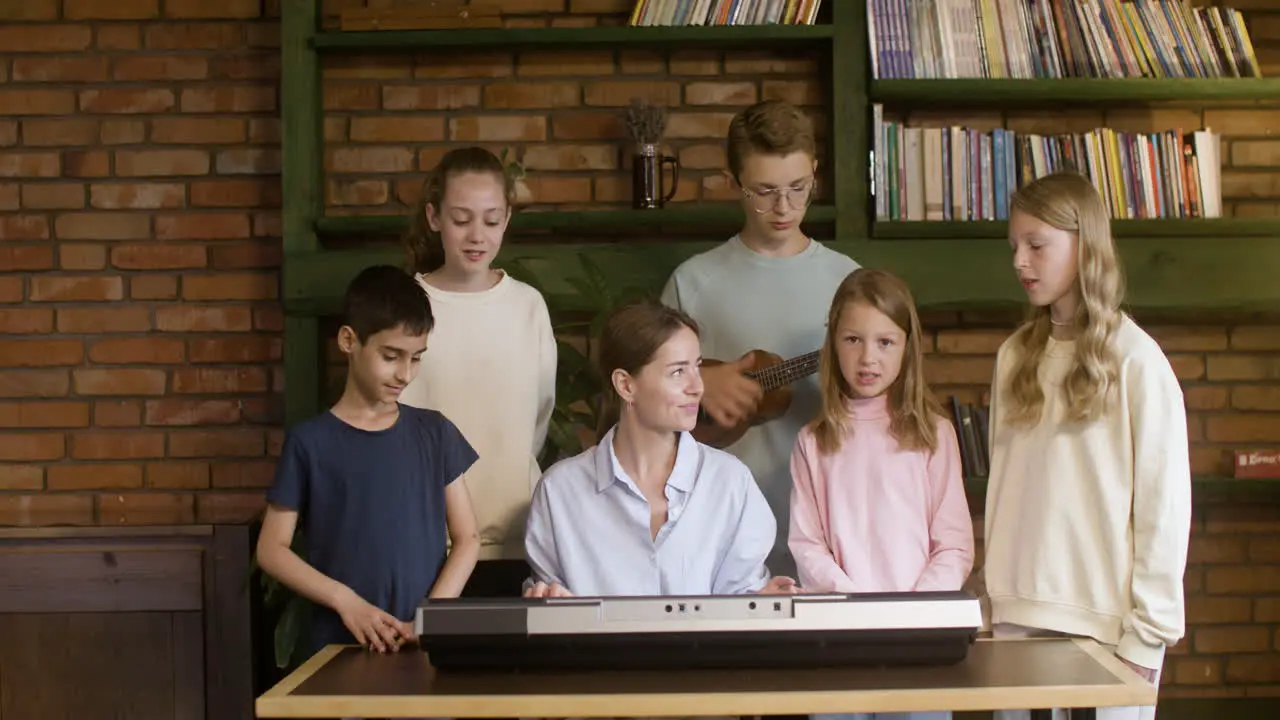 Estudiantes Cristianos Cantando Con Su Profesor Al Ritmo Del Teclado Y El Ukelele