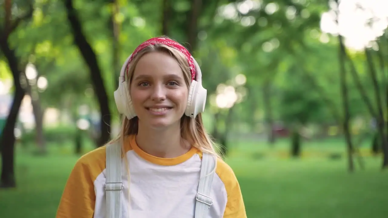 Retrato De Una Bella Joven Poniéndose Auriculares Disfrutando De La Música Y Bailando Al Aire Libre