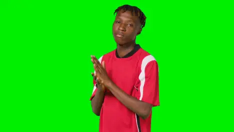 Studio Portrait Of Young Male Footballer Wearing Club Kit Against Green Screen