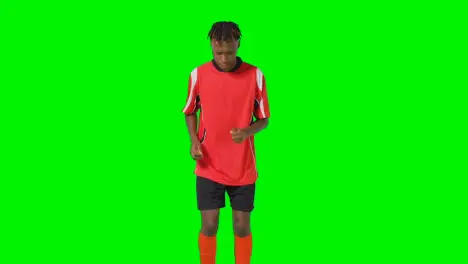 Studio Shot Of Young Male Footballer Warming Up With Exercises Before Game Against Green Screen 1