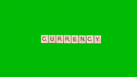 Stop Motion Business Concept Overhead Wooden Letter Tiles Forming Word Currency On Green Screen 1