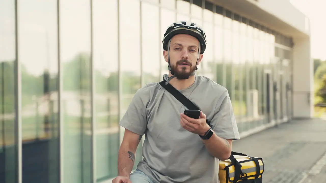 Der Verwirrte Essenslieferant Mit Thermorucksack Wirft Einen Blick Auf Sein Smartphone Um Zu Wissen Wohin Er Mit Seinem Fahrrad Fahren Soll