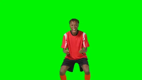 Portrait Of Young Male Footballer Wearing Club Kit Celebrating Goal Against Green Screen 3