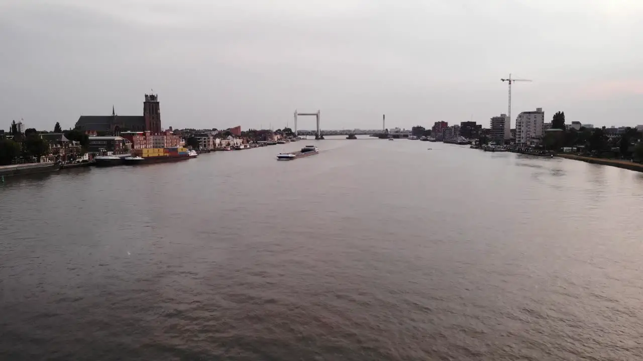 Cargo ship sailing on wide river in town