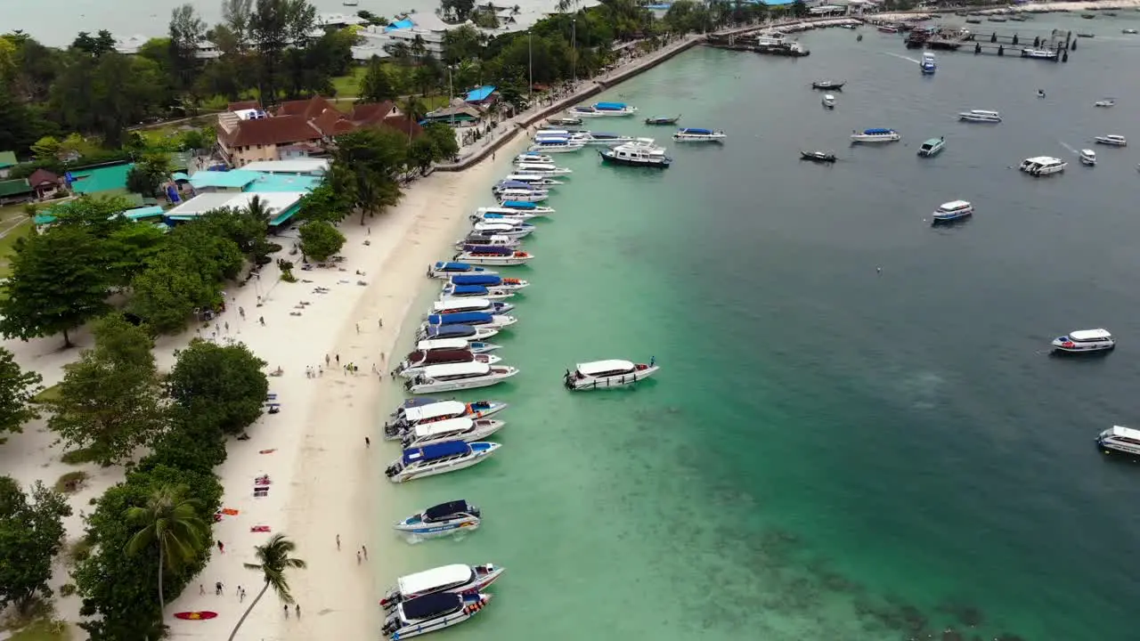 Coastal side boat parking in Phuket while people are swimming